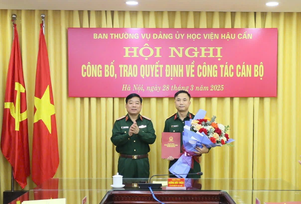 Trung tướng Dương Đức Thiện, Bí thư Đảng ủy, Chính ủy Học viện trao Quyết định và tặng hoa chúc mừng đồng chí Trung tá Nguyễn Anh Tuấn